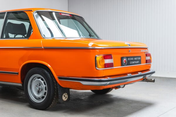 Rear quarter view of a 1975 BMW 2002 tii in Inka Orange.
