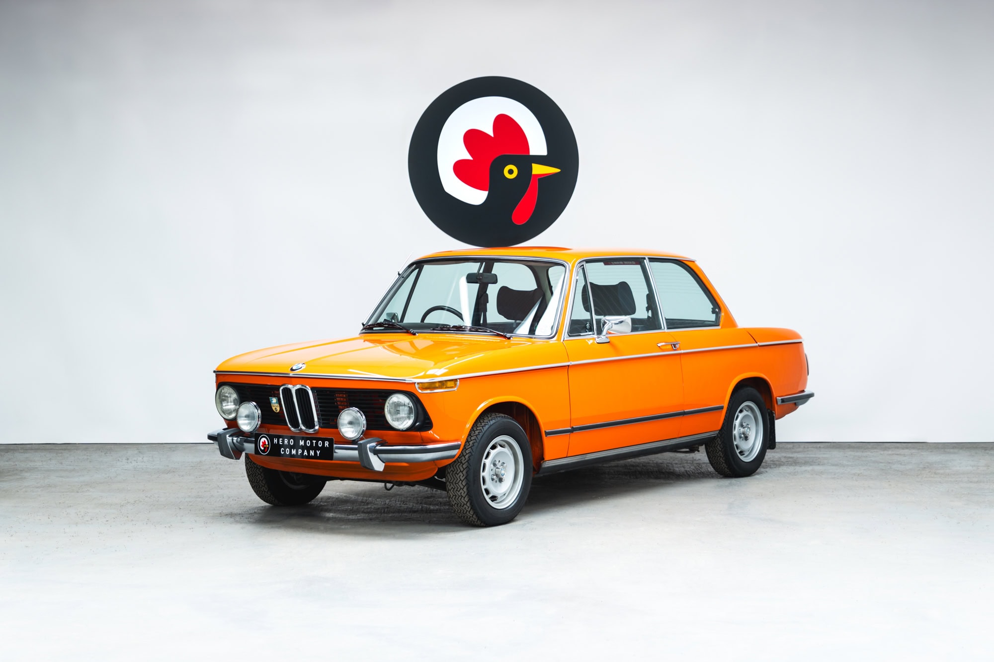Front quarter of an Inka Orange BMW 2002 tii at Hero Motor Company.