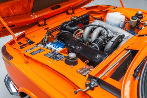 The engine bay of an Inka Orange BMW 2002 tii.