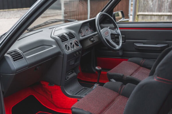 Landscape orientation of nearside interior view showing centre console and steering wheel on a Graphite Peugeot 205 GTI