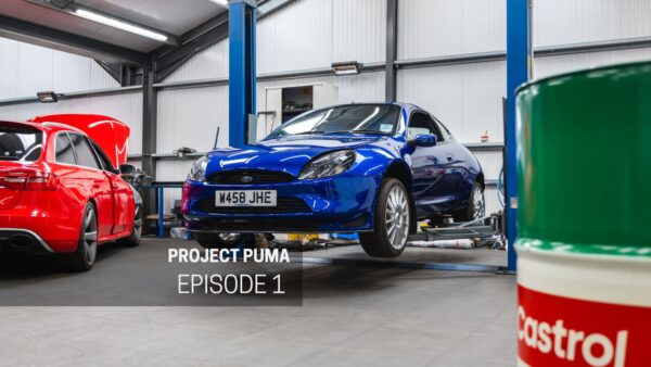 A performance blue Ford Racing Puma on a workshop ramp.