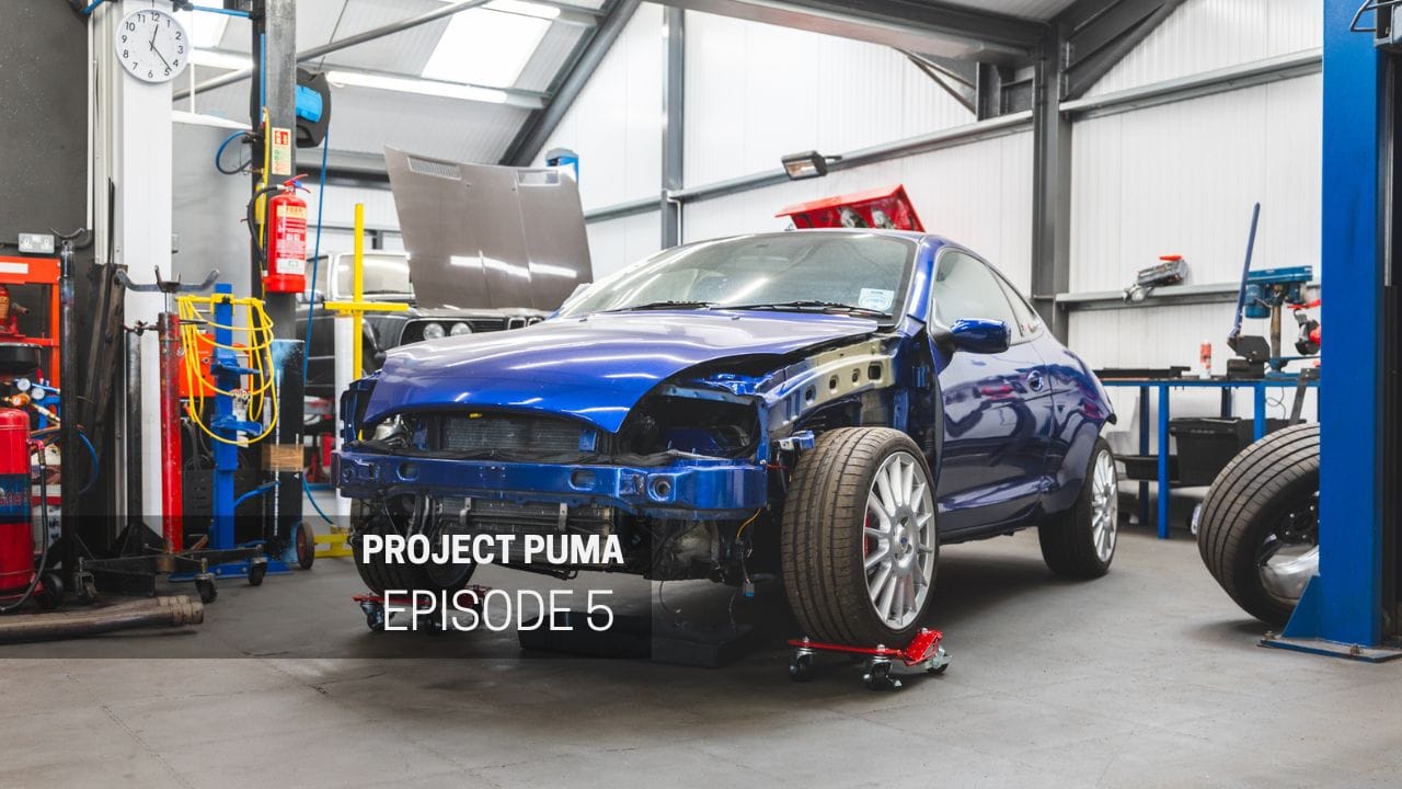 A blue Ford Racing Puma in a workshop.