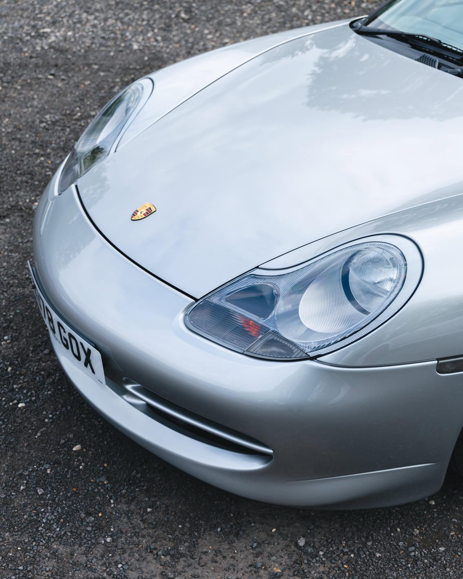 Front headlights and aero kit bumper of a silver Porsche 996.