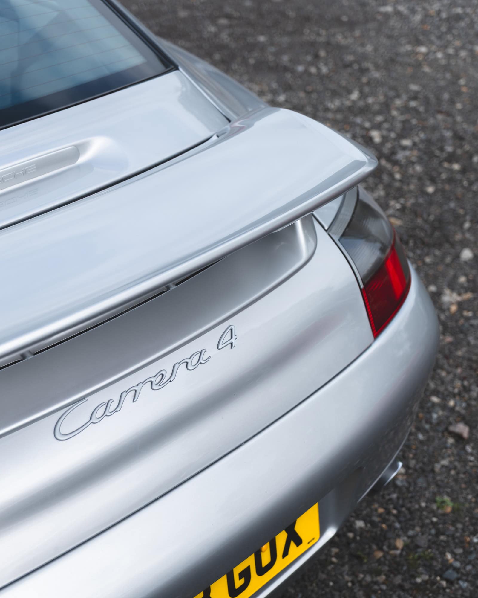 The rear spoiler of a silver porsche 996 Carrera 4