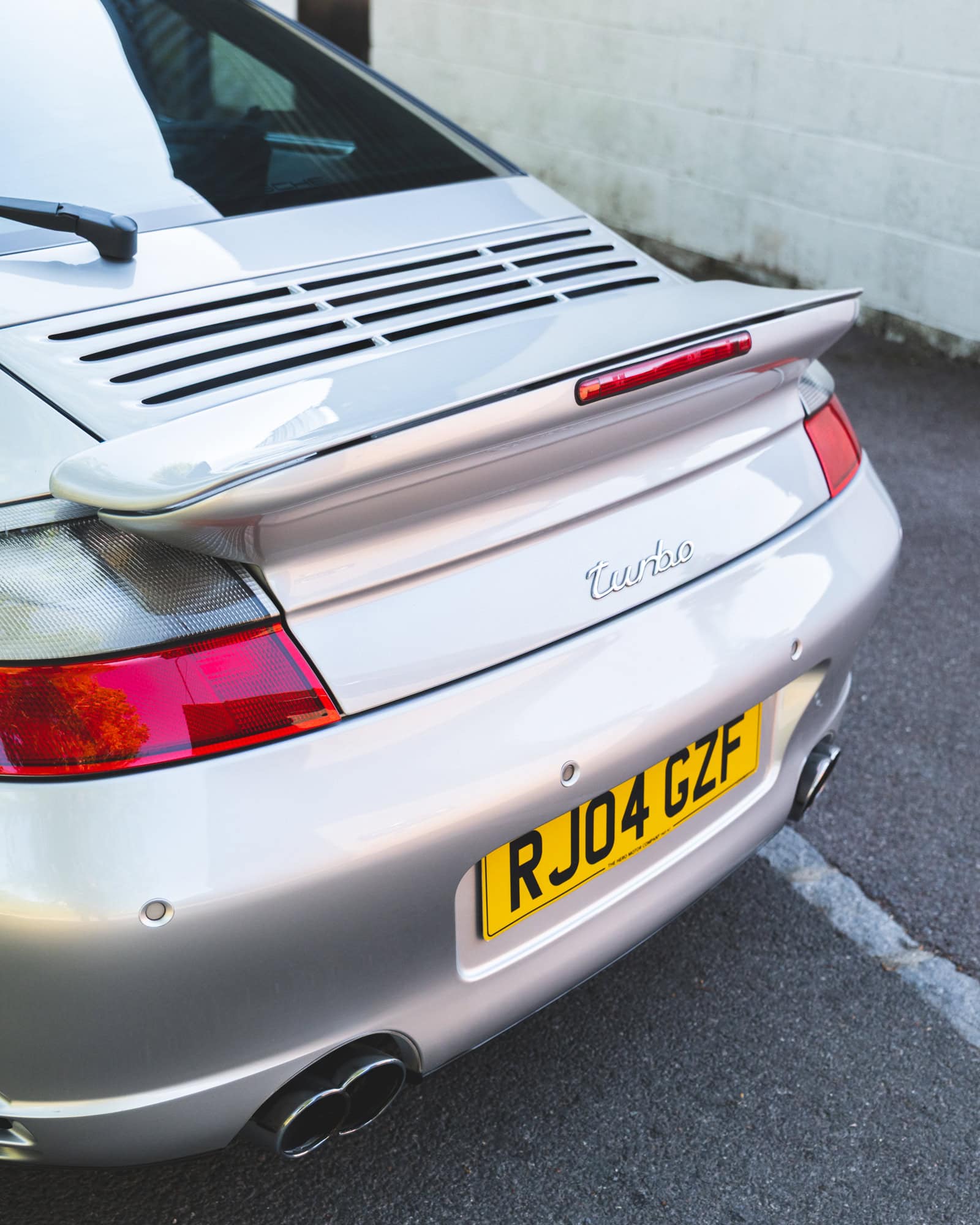 Rear spoiler of a silver Porsche 996 Turbo.