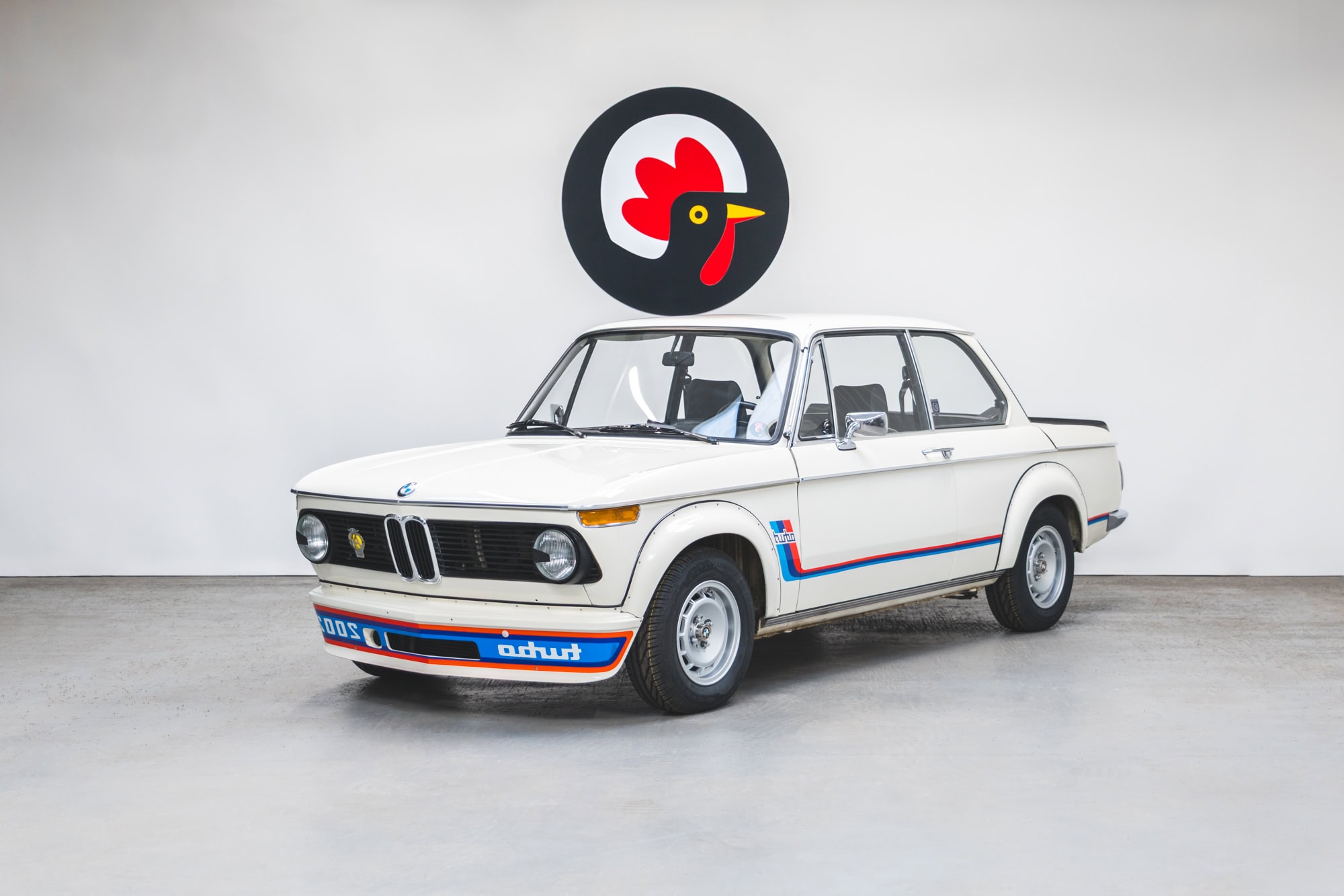 Front quarter view of a 1974 BMW 2002 Turbo in Chamonix White and Mahle Alloy Wheels.