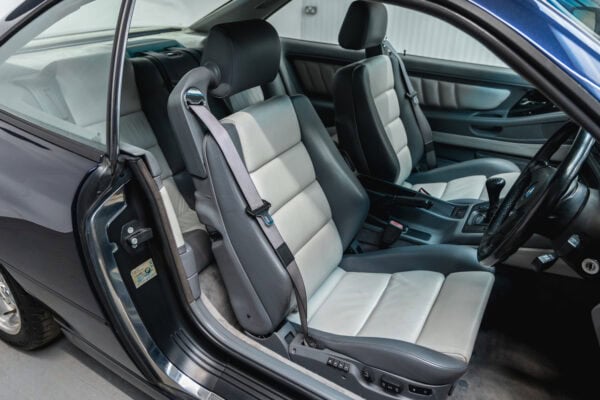Drivers front seat of a BMW 850 CSI coupe in orient blue metallic with silver and grey leather interior.